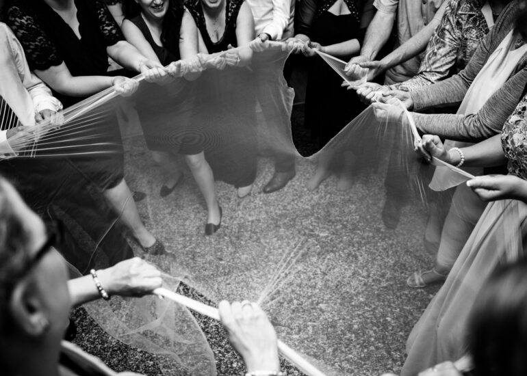 Hochzeitsgäste ziehen am Schleier